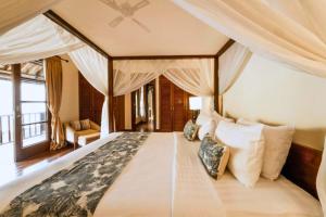 a bedroom with a large bed with a canopy at Majestic 3 BR Private Pool Villa NE18 in Jimbaran +9 photos