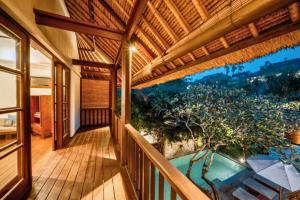 an outside balcony of a house with a pool at Majestic 3 BR Private Pool Villa NE18 in Jimbaran