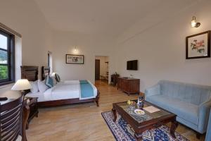 ein Wohnzimmer mit einem Bett und einem Sofa in der Unterkunft The Hunting Lodge Resort Udaipur - Villas & Pool in Dabok