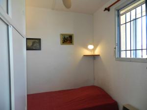 um quarto com uma cama e uma luz na parede em Appartement Le Lavandou, 4 pièces, 6 personnes - FR-1-251-805 em Le Lavandou