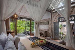 a living room with white curtains and a couch at Pramana Giri Kusuma in Payangan