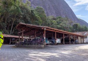 un edificio con coches estacionados frente a una montaña en Kastel Pedra Bonita, en Petrópolis