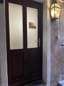 a wooden door with a light on a wall at Appartamento Vacanze - Holiday Apartment "Ortamore" in Orta San Giulio