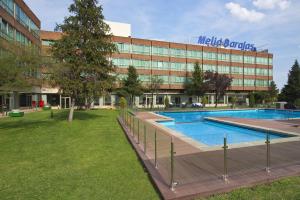 a large swimming pool in the middle of a grassy area at Melia Barajas in Madrid