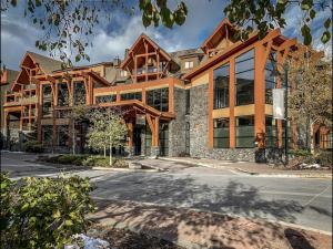 a large wooden building with a lot of windows at Luxury Resort 2Bedroom 2Bath Sleeps 6 945 square feet in Canmore