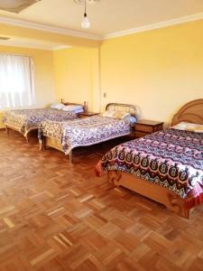 a bedroom with two beds and a wooden floor at Conquistador sucursal 1 in Copacabana +29 photos