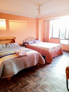 コパカバーナにあるHotel Amor de Diosのベッドルーム1室(ベッド2台、窓付)