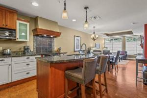 a kitchen with a counter and a bar with chairs at Luxury Resort 2BR/2Bath Sleeps 6 in Canmore