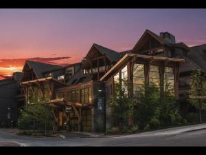 un gran edificio con una puesta de sol en el fondo en Luxury Resort 2BR/2Bath Sleeps 6, en Canmore