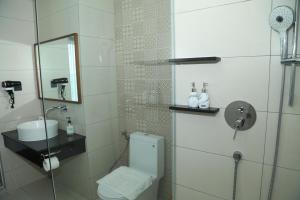 a bathroom with a toilet and a glass shower at Apec Mandala Sun-Condotel Phu Yen in Tuy Hoa