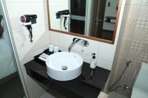 a bathroom with a white sink and a mirror at Apec Mandala Sun-Condotel Phu Yen in Tuy Hoa