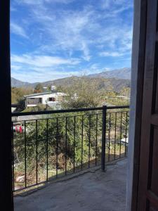 a balcony with a view of a house and mountains at Cabañas Viltez 2 in Tafí del Valle