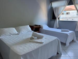 Cette chambre comprend 2 lits et une fenêtre. dans l'établissement Pousada da Barra Prado Bahia, à Prado