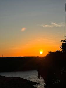 a sunset over a river with the sun setting at Pousada da Barra Prado Bahia in Prado