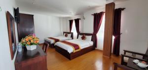 Postel nebo postele na pokoji v ubytování Tâm Dung Hotel Đà Lạt