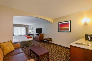 um quarto de hotel com uma cama e uma sala de estar em Holiday Inn Express Hotel & Suites Salina, an IHG Hotel em Salina