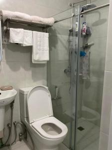 a bathroom with a toilet and a glass shower at Brand new and fully furnished home away from home! in Manila