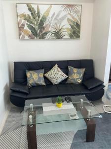 a black couch with pillows and a glass table at Brand new and fully furnished home away from home! in Manila