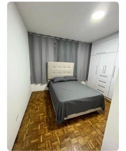 um quarto com uma cama e piso em madeira em Renewed apt in Altamira, the heart of Caracas em Caracas