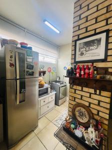 a kitchen with a stainless steel refrigerator next to a brick wall at Apartamento com localização fantástica na praia de Balneário Camboriú in Balneário Camboriú