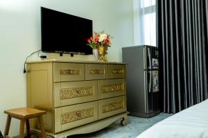 a tv on top of a dresser in a bedroom at Tân Hiệp Hotel in Bùi Tiếng