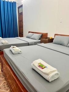 2 Betten in einem Zimmer mit Handtüchern darauf in der Unterkunft Thành Đạt Hostel ( Hostel and Motobike Rental ) in Bản Tùy