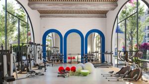 um ginásio com muitos equipamentos de exercício e grandes janelas em SANTORINI BLUE LUX em Negombo