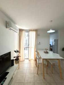 cocina y comedor con mesa blanca y sillas en Alojamiento confortable para tus días en Córdoba. en Córdoba