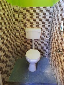 uma casa de banho com WC num quarto com azulejos em Hotel Sun Plaza Near Konark Sun Temple & Couple Friendly em Konarka