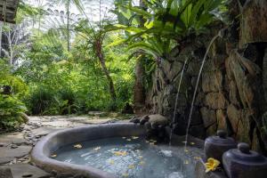 a bath tub in the middle of a garden at Pramana Giri Kusuma in Payangan