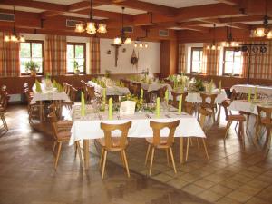 comedor grande con mesas y sillas blancas en Reischacher Hof, en Reischach