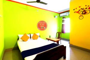 um quarto verde com uma cama e uma cadeira em Hotel Sun Plaza Near Konark Sun Temple & Couple Friendly em Konarka