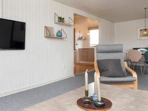 Una sala de estar con un televisor y una silla. en 6 person holiday home in Haderslev-By Traum, en Haderslev