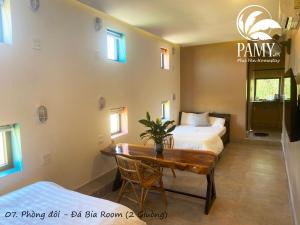 a room with two beds and a table with a desk at PAMY Homestay Phú Yên in Phu Yen