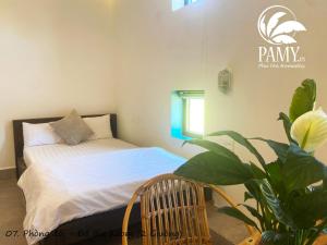um quarto com uma cama e um vaso de plantas em PAMY Homestay Phú Yên em Phu Yen