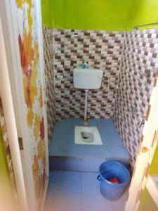 a small bathroom with a toilet and a bucket at Hotel Sun Plaza Near Konark Sun Temple & Couple Friendly in Konārka