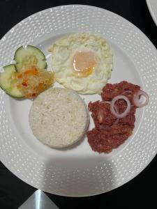 um prato de alimentos com ovos, carne e produtos hortícolas em Arzel's Tiny House em Mangatarem