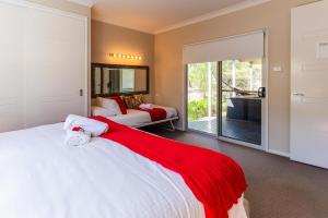 a bedroom with a bed and a living room at Hunter Moon Country House, Hunter Valley in Broke