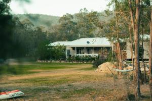 a large white house with a porch at Hunter Moon Country House, Hunter Valley in Broke