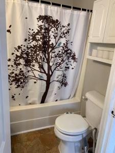 a bathroom with a shower curtain with a tree at Chic Home Away From Home! in Bowling Green