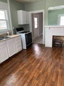 a kitchen with a wooden floor and a fireplace at Chic Home Away From Home! in Bowling Green