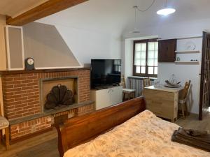 a bedroom with a bed and a brick fireplace at CasArte: monolocale TERRA in Alpignano