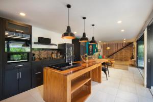 a kitchen with black cabinets and a wooden counter top at Gorgeous Villa Fizia in Bingin Center in Uluwatu