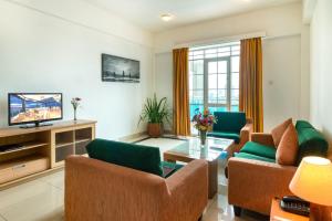 een woonkamer met 2 banken en een tv bij Global Towers Hotel & Apartments in Colombo