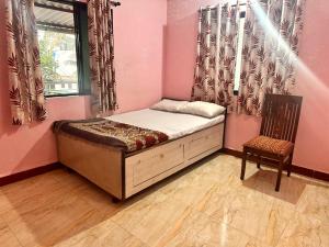 una piccola camera con letto e sedia di Homestay 2 bhk near beach ad Alibaug