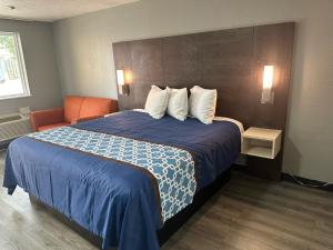 a hotel room with a large bed with a blue blanket at Masters Inn Augusta Washington Rd, I-20 in Augusta