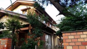 a brick house with a tree in front of it at メゾン102号 Mason Guest House Suite 102 in Matsudo