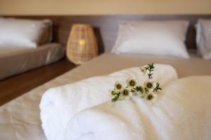 a bed with a white blanket and flowers on it at Thom Farm and Retreat in Teurnoum
