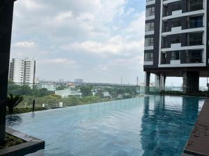 a swimming pool in front of a building at Khu nghĩ dưỡng Emerald Golf View in Thuan An