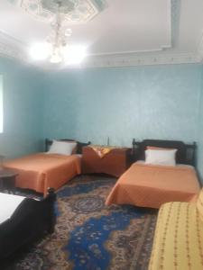 2 Betten in einem Zimmer mit blauen Wänden in der Unterkunft maison d hote timentour in Tiguissas